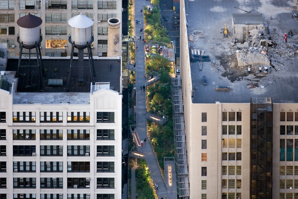 High Line, Section 2 - 2013 General Design Honor Award Winner Aerial View of The Woodland Flyover. A metal walkway rises eight feet above the High Line, allowing groundcover plants to blanket the undulating terrain below, and carrying visitors upward, into a canopy of sumac and magnolia trees. image: Iwan Baan