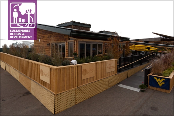 A well-designed home is oriented according to natural patterns, such as high-velocity air flow. In order to act as a wind-break for the cool winter winds of West Virginia, the WVU Solar Decathlon house included tall grasses around the structure.  image: John Wray, Team WVU / U.S. Department of Energy Solar Decathlon