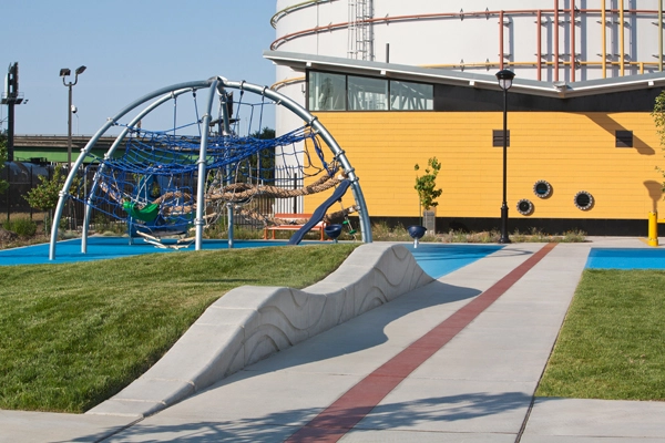 Wave-like forms and an industrial aesthetic relate play equipment to the water infrastructure in Jerome D. Barry Park, a neighborhood park in West Sacramento, CA, designed by Callander Associates. image: Billy Hustace