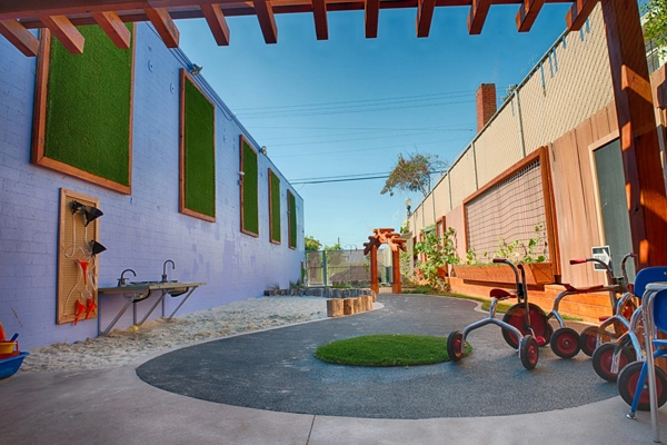 After. View looking South. The tricycle track is the spine that runs through the yard. Vertical planters help to soften the walls, providing planting areas, and maximizing the ground level for play. image: Alex Calegari