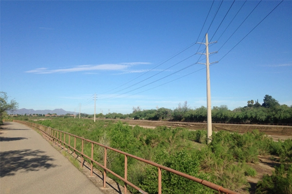 Figure 8: Light colored transmission poles, despite fading, contrast minimally with sky. Poles shown here are in the Rillito River along the Rillito River Park in Tucson, AZ. Installation date unknown. image: Ellen Alster