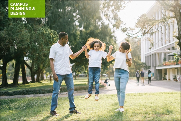 Family playing on grassy area in front of building