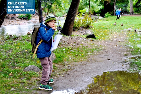 A third grade student exploring an outdoor space with peers