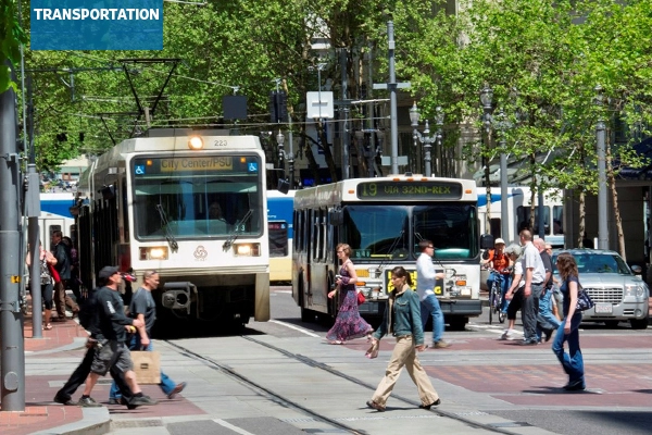 A busy street in Portland, Oregon with pedestrians, buses, and trams