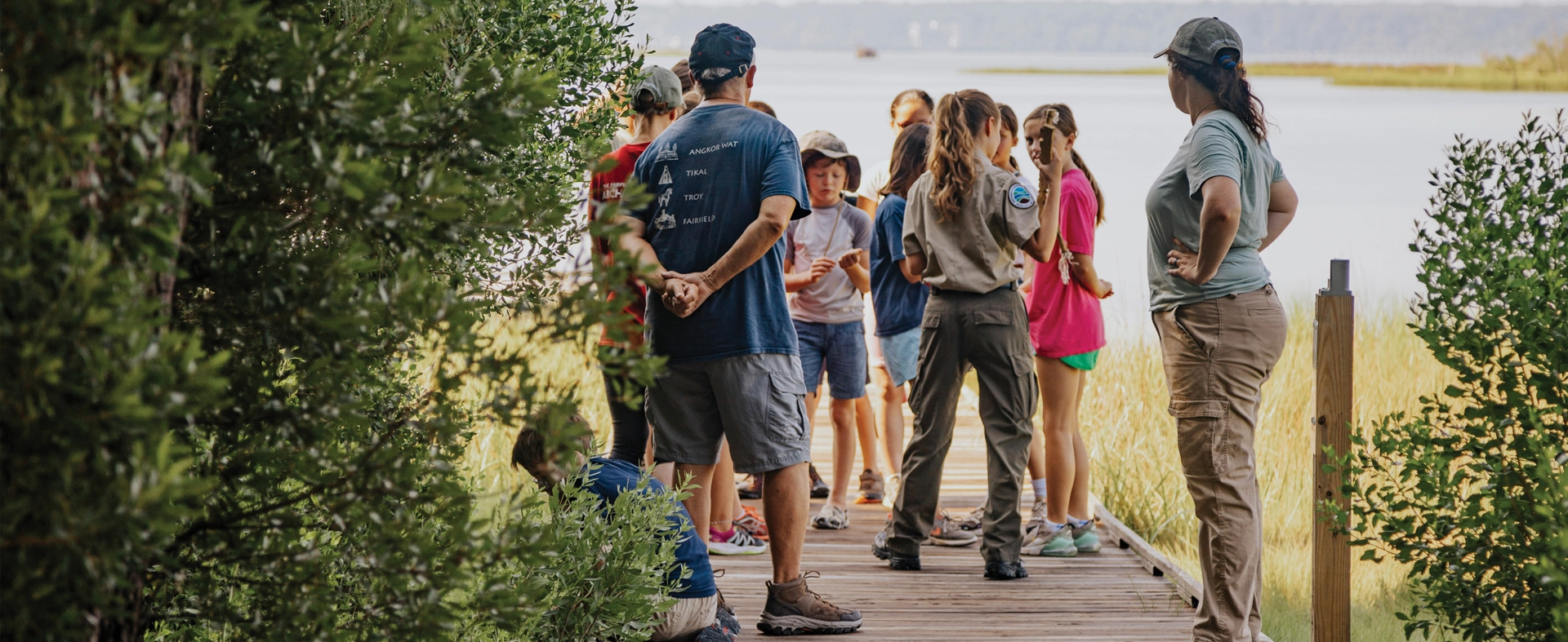 A group of visitors at Machicomoco State Park listening to a park guide