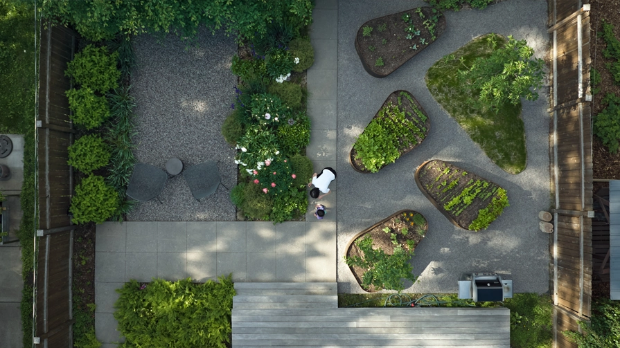 Aerial view of backyard designed as a space for family gatherings, outdoor dining, play, and shared gardening experiences