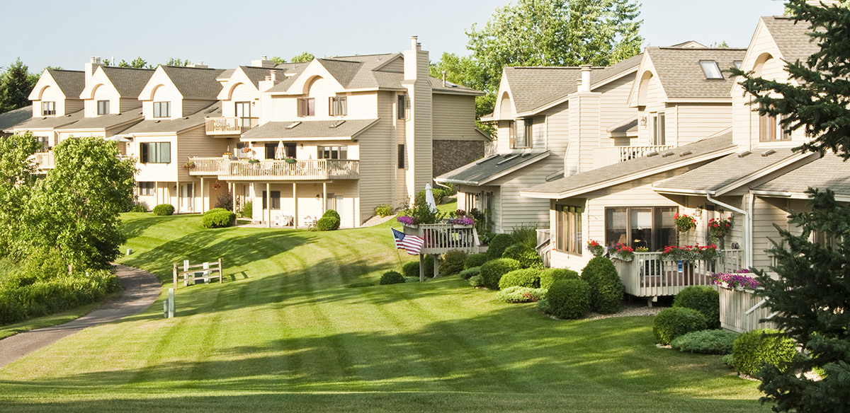 Sidewalk running through a field of grass in a suburban neighborhood